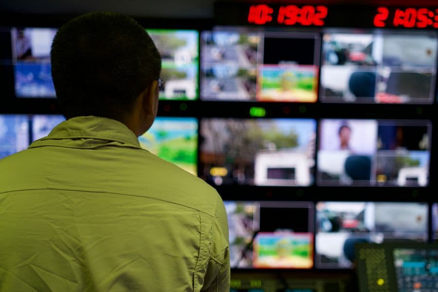 A person monitoring multiple screens in a studio control room